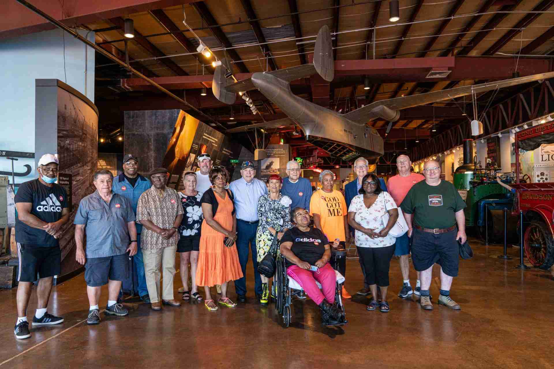 A diverse group of former steelworkers stand inside the BMI's Decker Gallery.