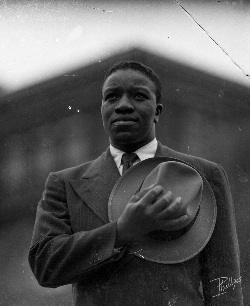 Young Black Man/Soldier holding hat over heart